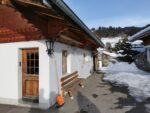 Modell-Seilbahn an der Hauswand, die kleinen Sesselgondeln fahren sogar nach oben